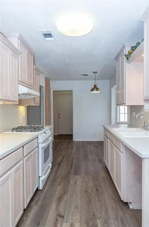 a kitchen with a sink stove and cabinets