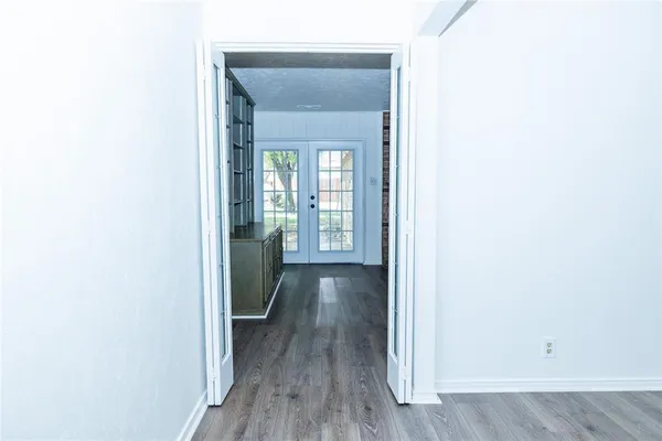 a view of a hallway with wooden floor