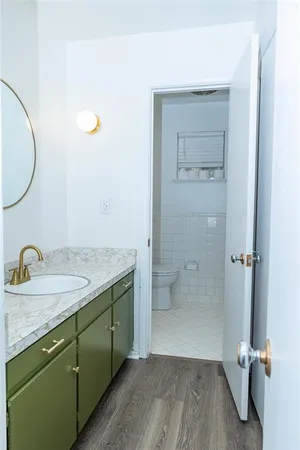 a bathroom with a granite countertop sink a toilet and a mirror