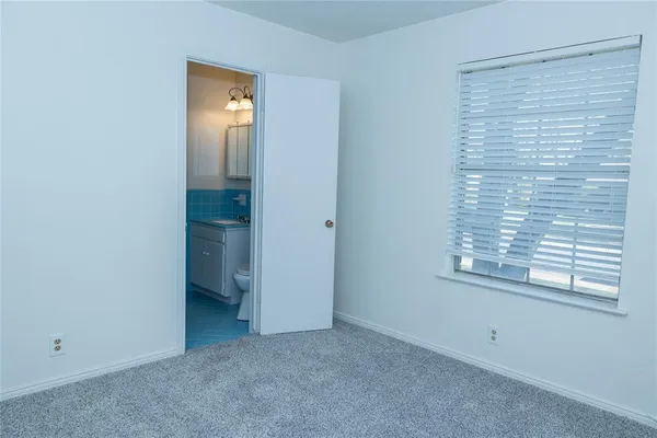 an empty room with a window and a bathroom