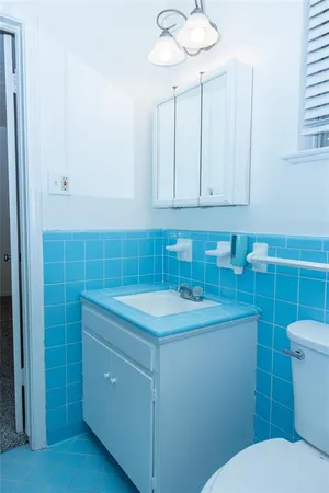 a bathroom with a toilet sink and mirror