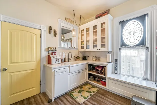 a kitchen with a sink stove and wooden floor