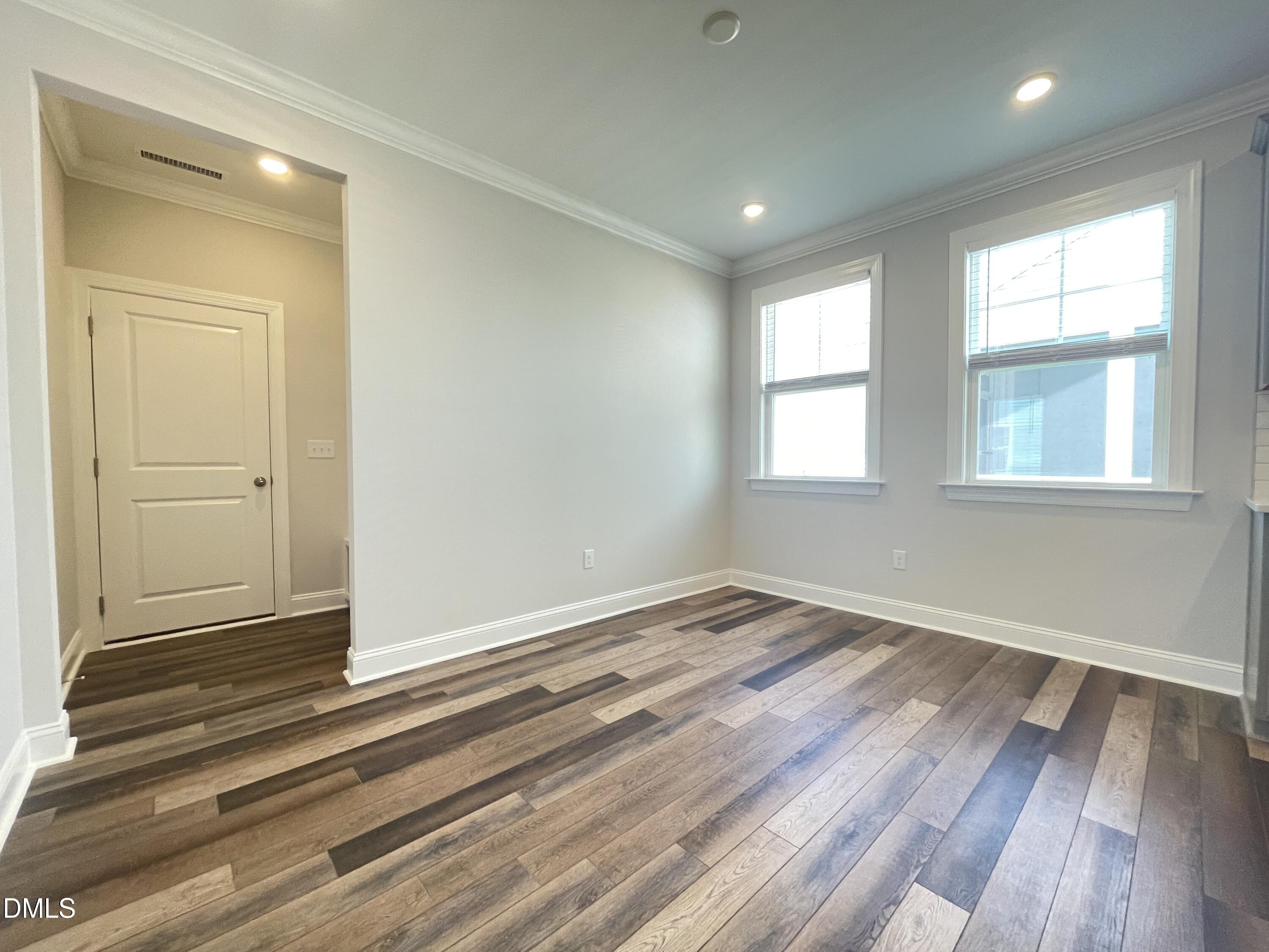 152 Baymouth Lane Raleigh, NC 27610 - Photo 11 of 34 an empty room with wooden floor and windows