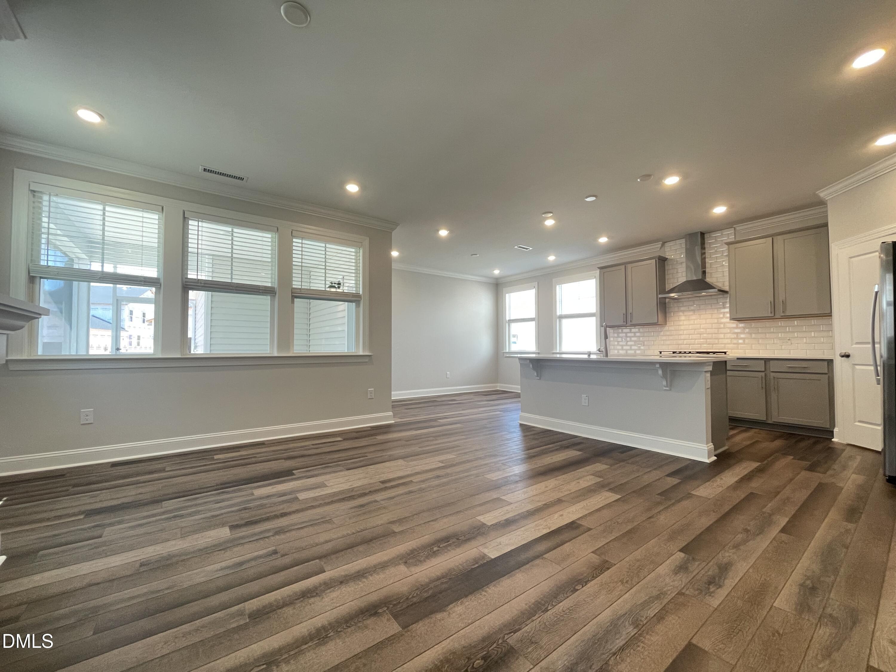 152 Baymouth Lane Raleigh, NC 27610 - Photo 4 of 34 a view of an empty room with wooden floor and kitchen