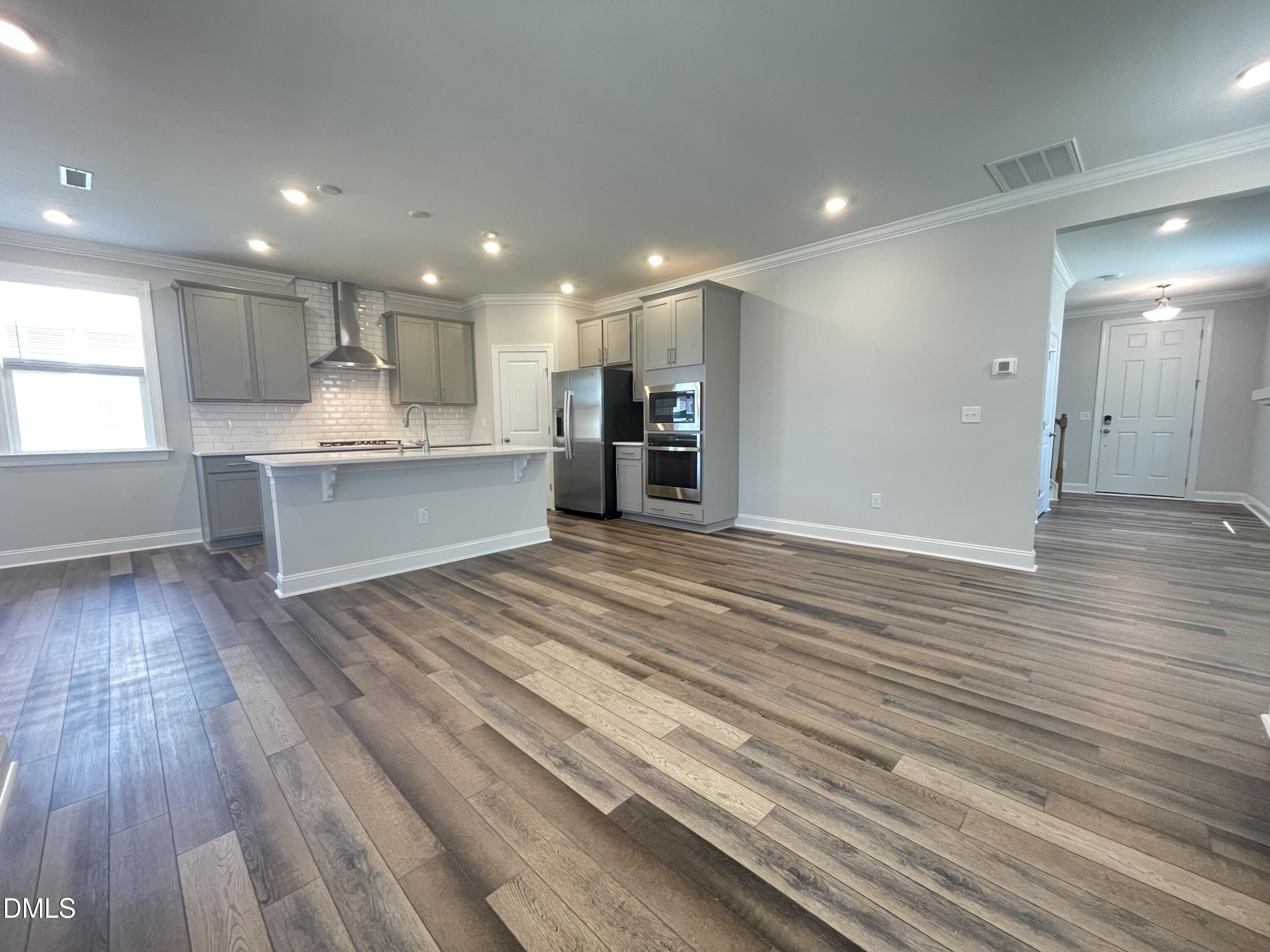 152 Baymouth Lane Raleigh, NC 27610 - Photo 6 of 34 a open kitchen with kitchen island a sink dishwasher stove and wooden cabinets