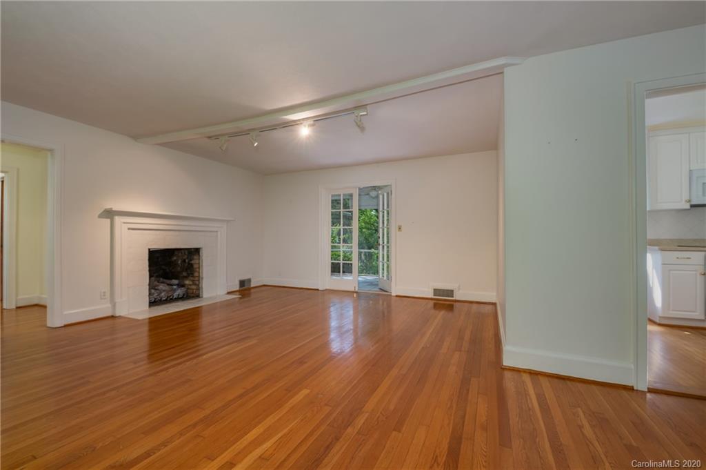 300 Doubleday Road Tryon, NC 28782 - Photo 11 of 38 an empty room with wooden floor and fireplace