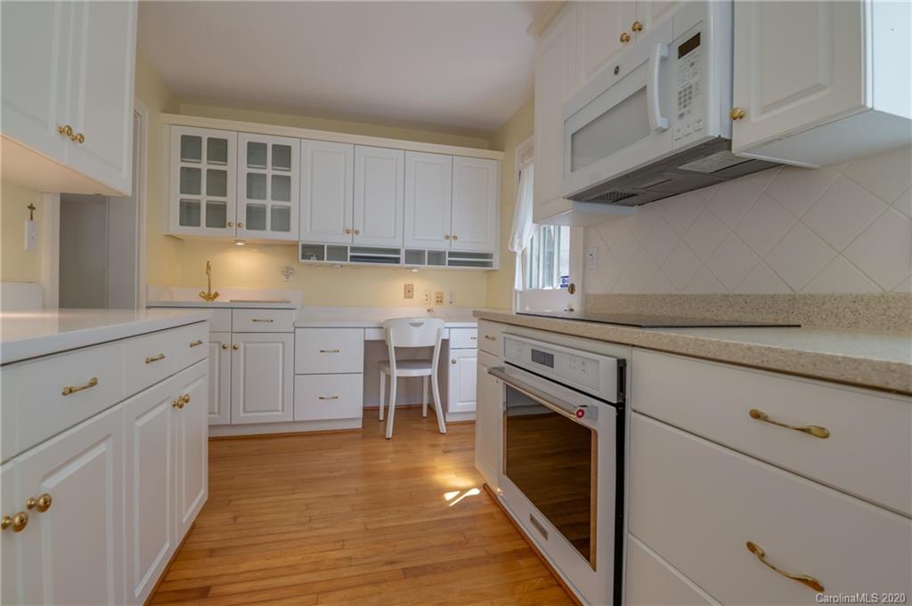 300 Doubleday Road Tryon, NC 28782 - Photo 15 of 38 a kitchen with granite countertop white cabinets stainless steel appliances and sink