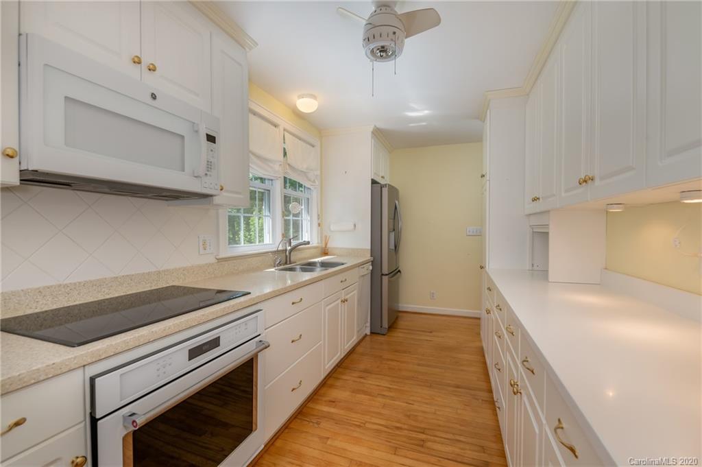 300 Doubleday Road Tryon, NC 28782 - Photo 16 of 38 a kitchen with granite countertop white cabinets and white appliances