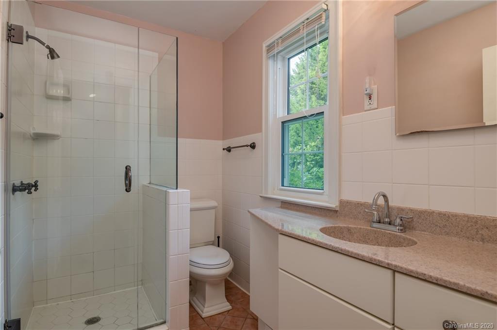 300 Doubleday Road Tryon, NC 28782 - Photo 29 of 38 a bathroom with a granite countertop sink a toilet a shower and a window