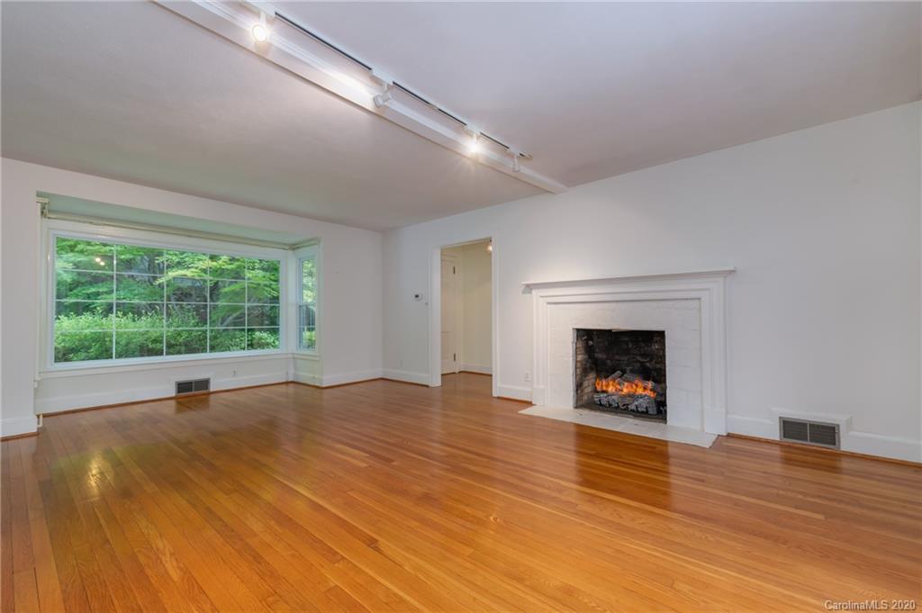 300 Doubleday Road Tryon, NC 28782 - Photo 9 of 38 a view of an empty room with wooden floor a fireplace and a window