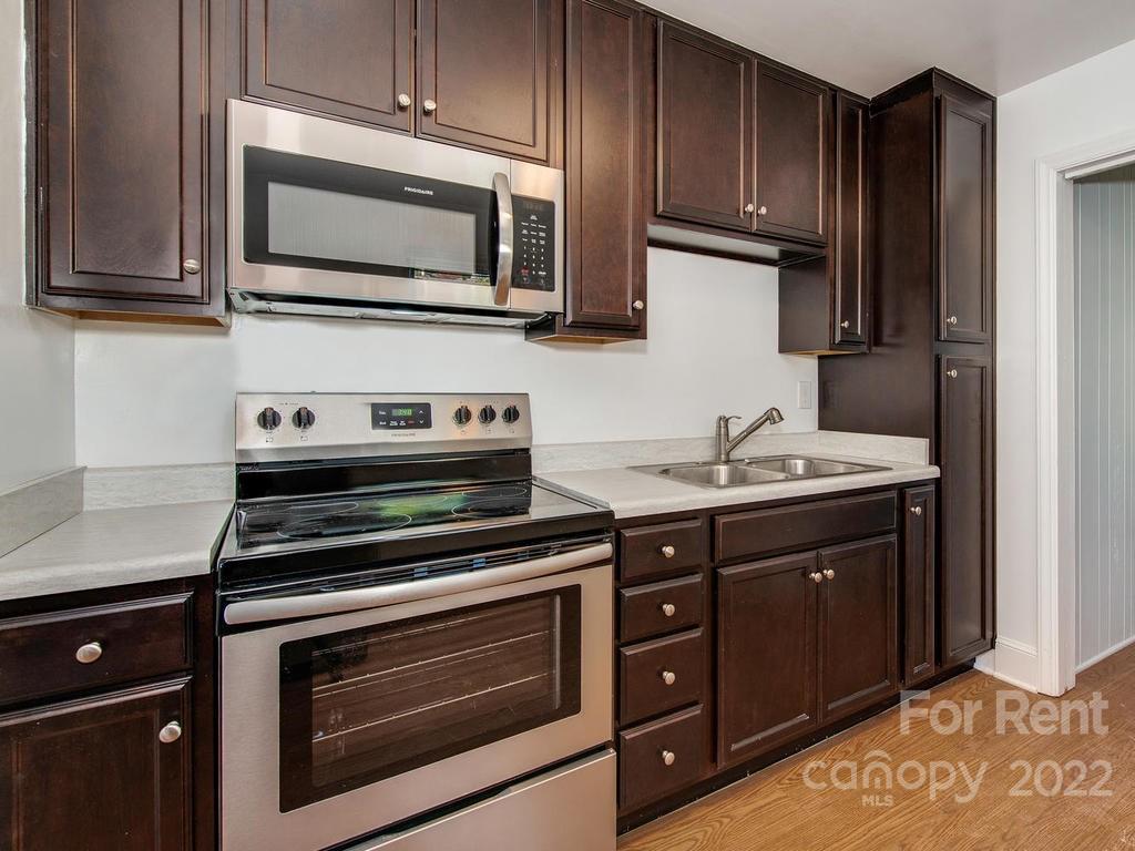 943 B Norland Road, Unit B Charlotte, NC 28205 - Photo 8 of 17 a kitchen with stainless steel appliances a stove microwave and cabinets
