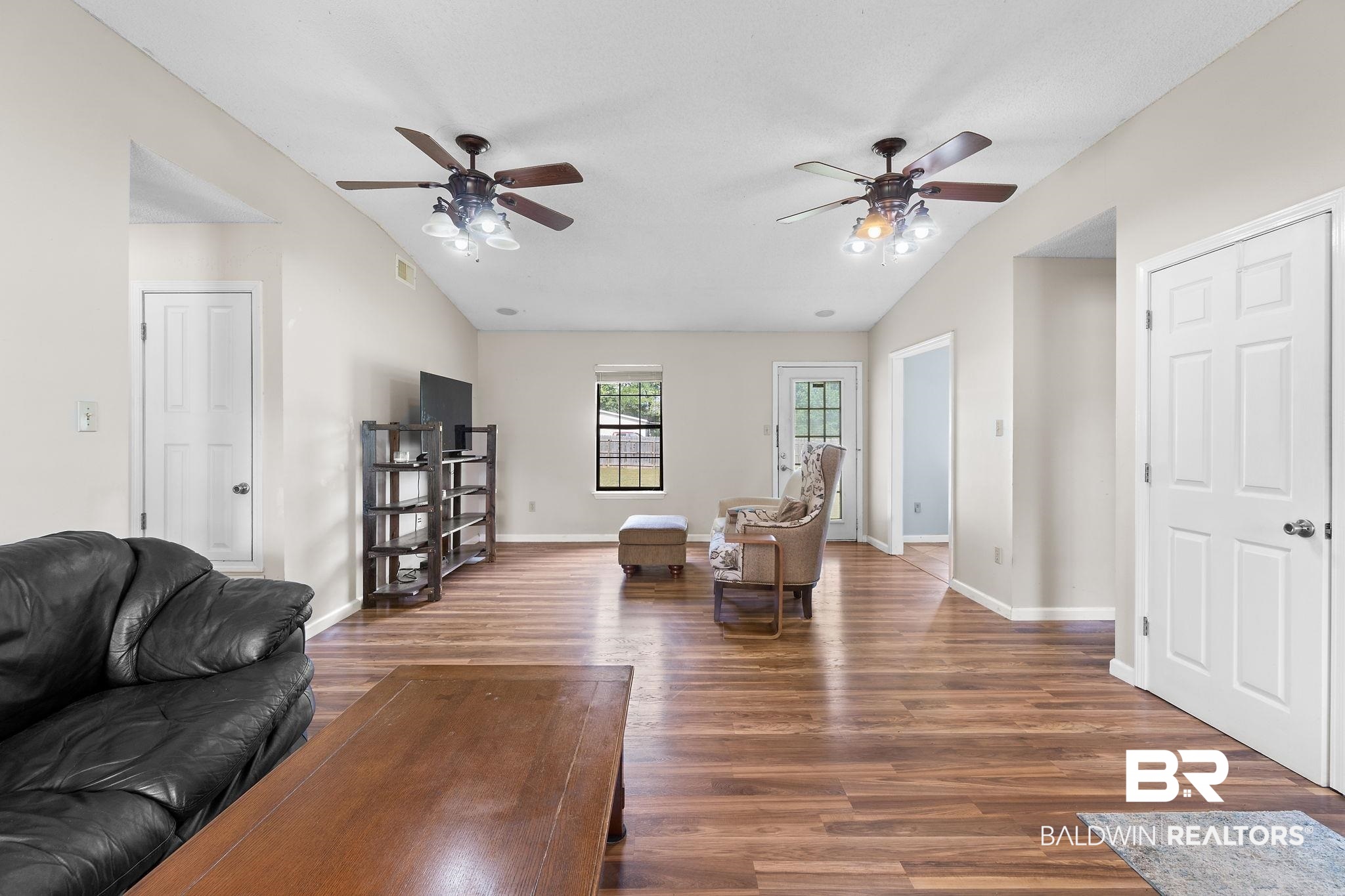 33135 Collier Road Lillian, AL 36549 - Photo 6 of 30 Living room with dark wood-style flooring, vaulted ceiling, and a ceiling fan