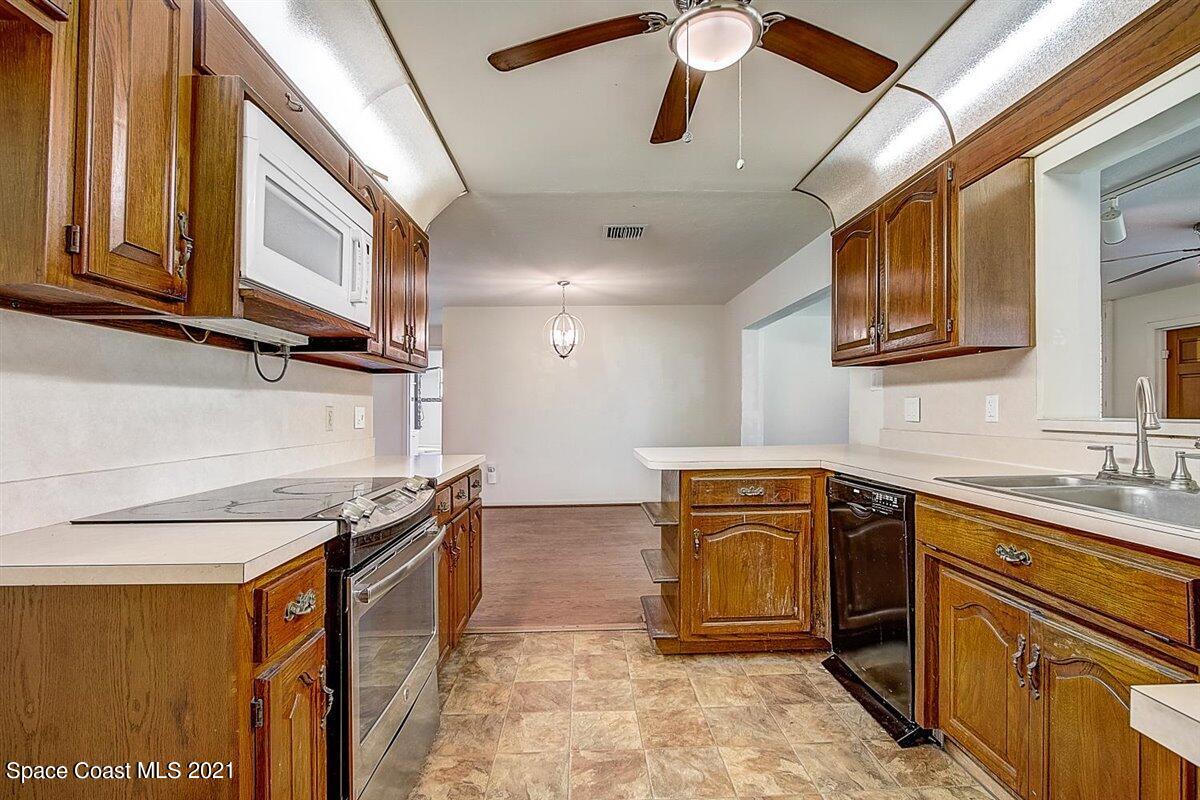 805 Knecht Road Northeast Palm Bay, FL 32905 - Photo 16 of 42 a kitchen with stainless steel appliances granite countertop a stove and a sink