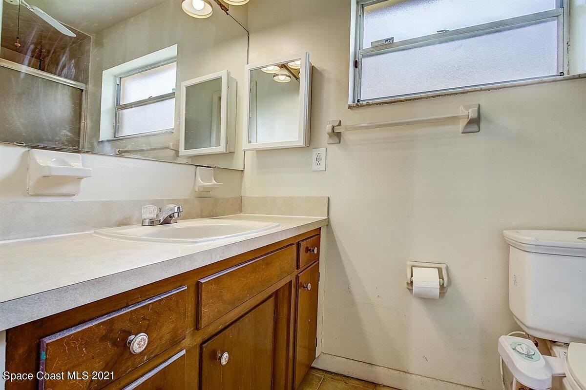 805 Knecht Road Northeast Palm Bay, FL 32905 - Photo 21 of 42 a bathroom with a sink a toilet and mirror