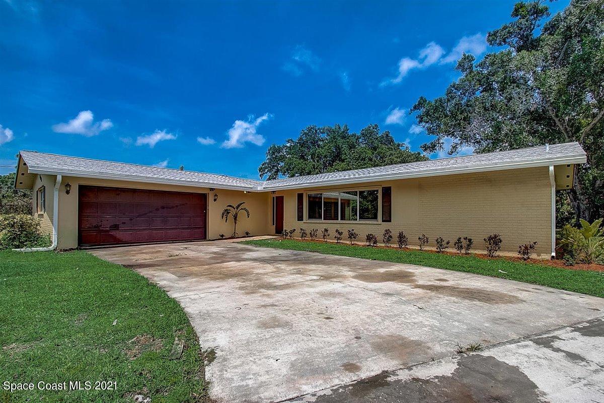 805 Knecht Road Northeast Palm Bay, FL 32905 - Photo 4 of 42 a front view of a house with a garden and trees