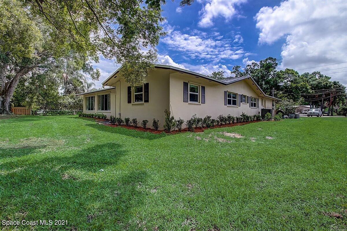 805 Knecht Road Northeast Palm Bay, FL 32905 - Photo 40 of 42 a white house that has a tree in front of it