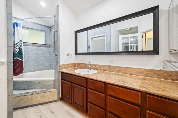 a bathroom with a granite countertop sink and a mirror