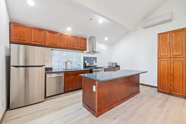 a view of kitchen with wooden floor and electronic appliances