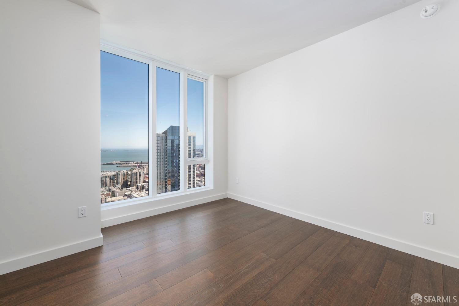 488 Folsom Street, Unit 4305 San Francisco, CA 94105 - Photo 13 of 45 an empty room with wooden floor and windows