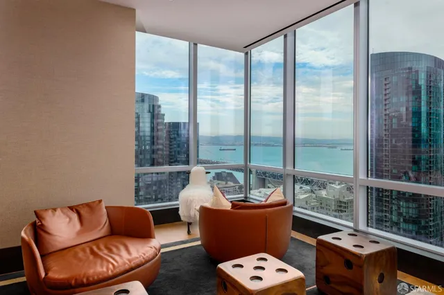 a swimming pool with large glass windows and outdoor seating