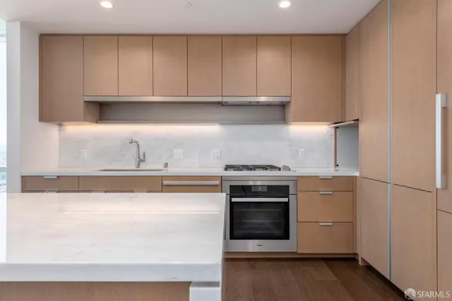 a kitchen with stainless steel appliances granite countertop a stove a microwave and a refrigerator