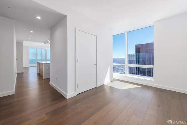 a view of a big room with wooden floor and windows