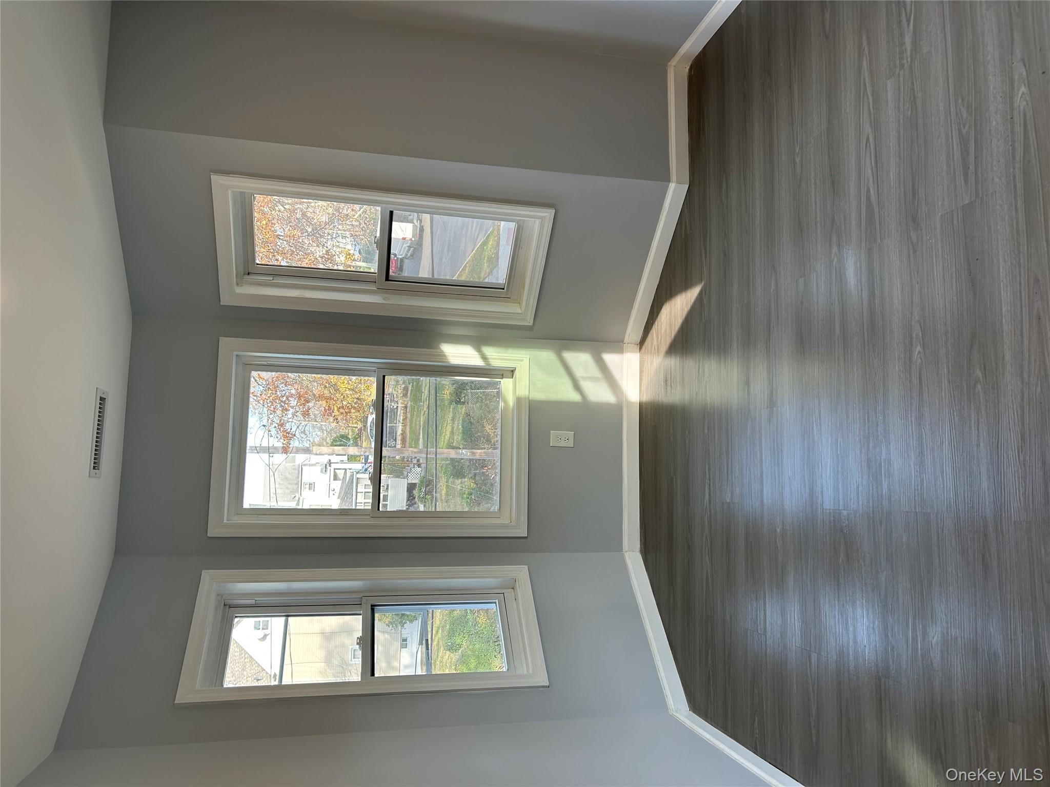 562 South 9th Avenue Mount Vernon, NY 10550 - Photo 7 of 8 a view of an empty room with wooden floor and a window