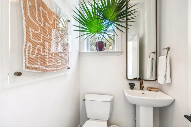a bathroom with a toilet sink vanity and mirror