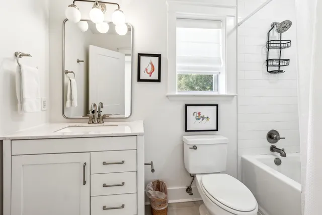 a bathroom with a granite countertop toilet sink and mirror