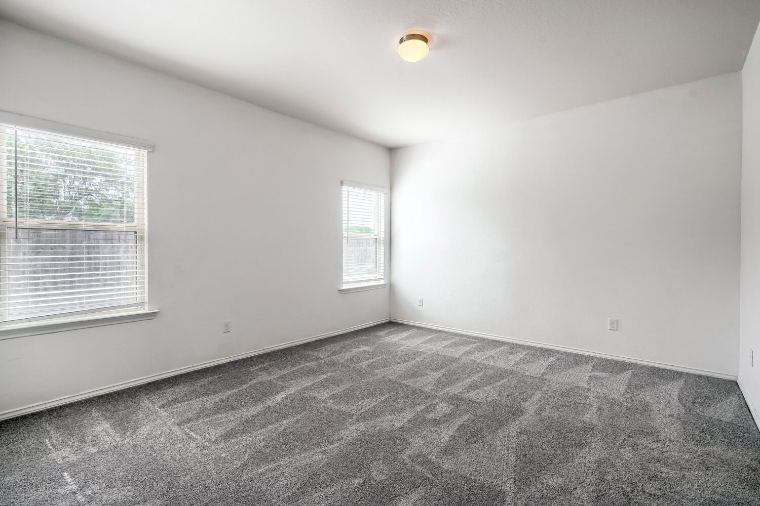 2420 Ranger Pass Seguin, TX 78155 - Photo 20 of 28 Spacious room featuring neutral paint, patterned carpet flooring, two windows with blinds, and an overhead light fixture