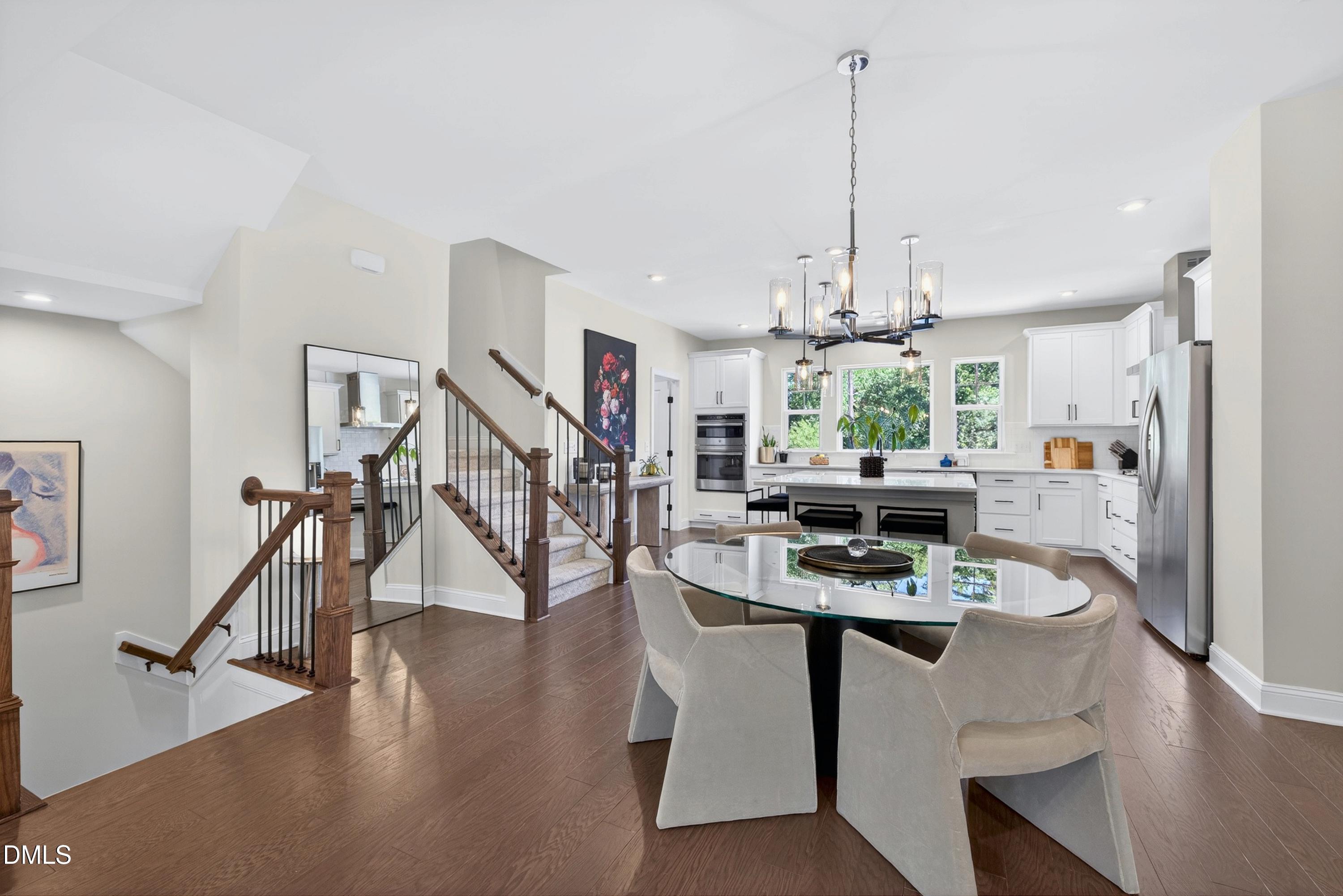 1063 Danvers Loop Apex, NC 27523 - Photo 16 of 67 a dining room with furniture a chandelier and wooden floor