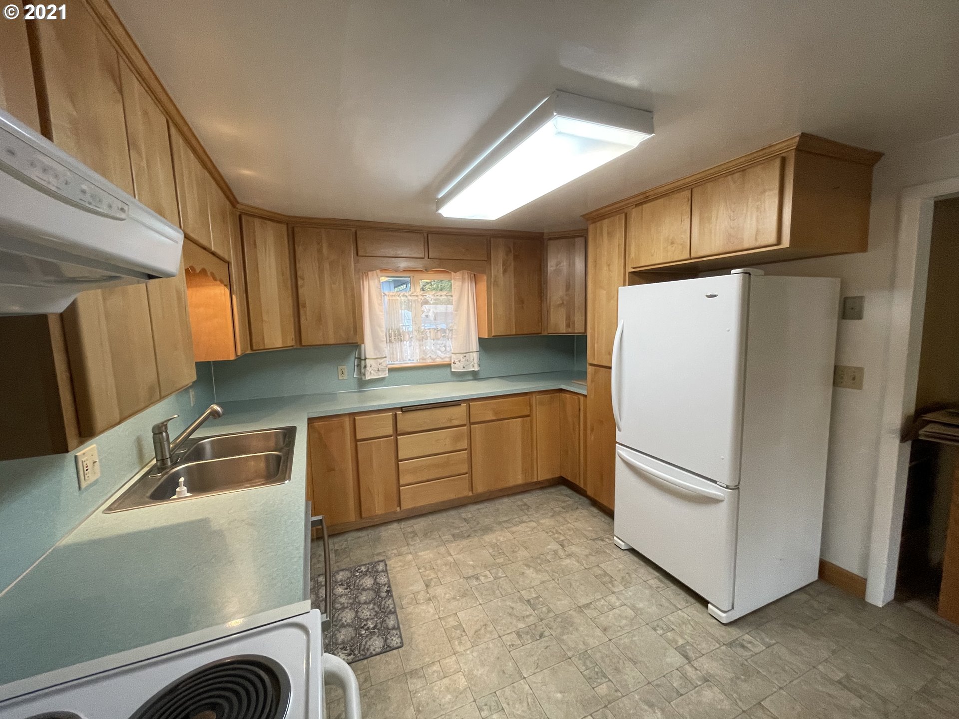 2002 H Street Springfield, OR 97477 - Photo 16 of 17 a kitchen with granite countertop a refrigerator and a sink