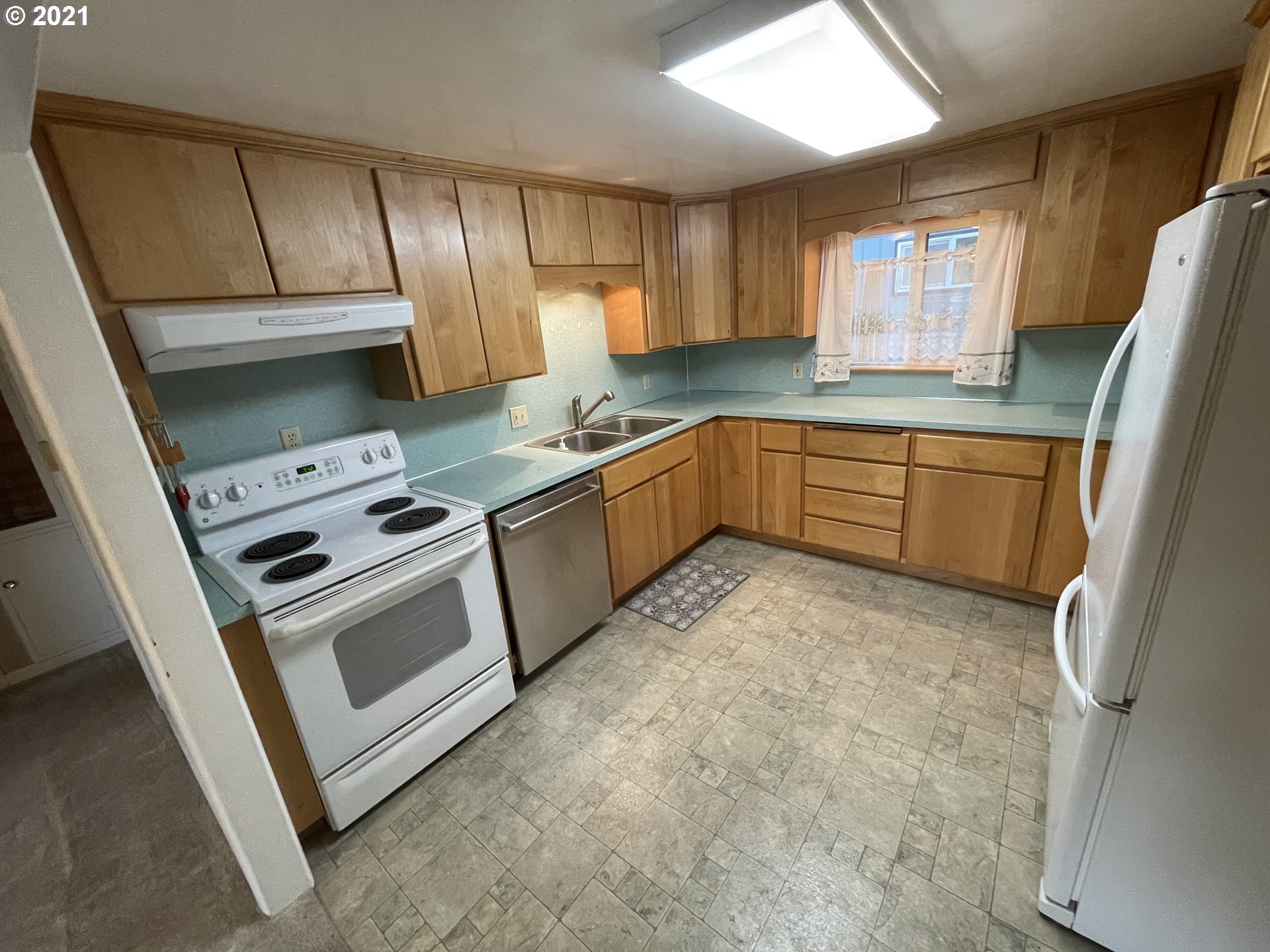2002 H Street Springfield, OR 97477 - Photo 5 of 17 a kitchen with stainless steel appliances granite countertop a sink a stove a refrigerator with grey cabinets