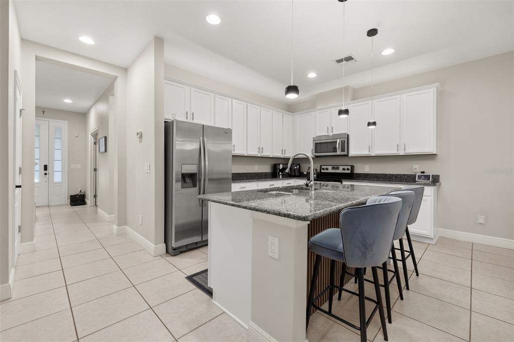 12333 Via Derna Place Windermere, FL 34786 - Photo 13 of 56 a kitchen with stainless steel appliances granite countertop a refrigerator and a stove top oven