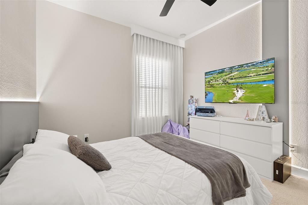 12333 Via Derna Place Windermere, FL 34786 - Photo 28 of 56 a bedroom with a bed and a flat tv screen on dresser