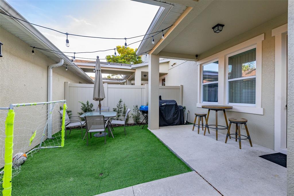 12333 Via Derna Place Windermere, FL 34786 - Photo 40 of 56 a view of a patio with table and chairs and a barbeque
