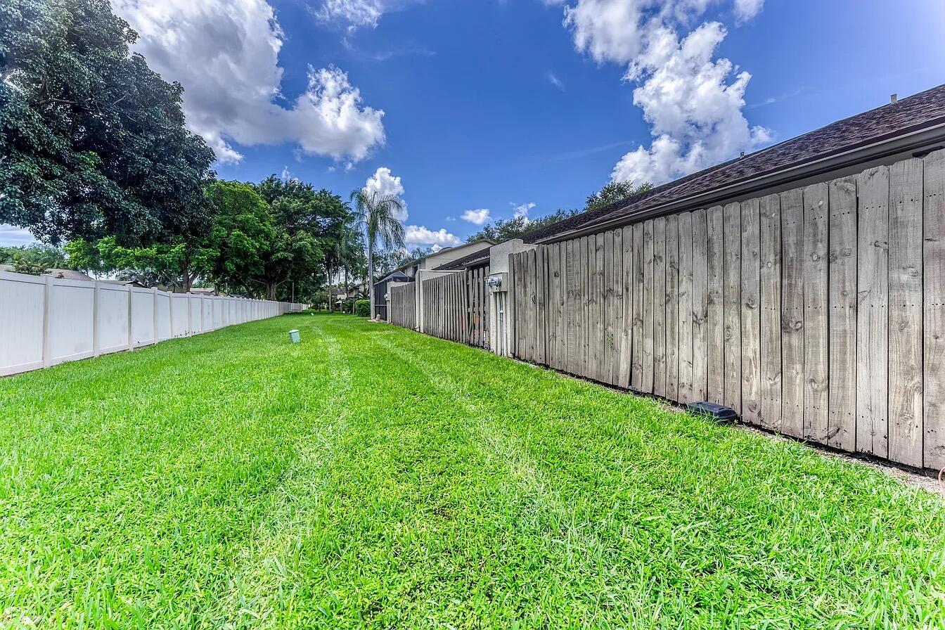 23284 Southwest 53rd Avenue, Unit D Boca Raton, FL 33433 - Photo 13 of 22 a backyard of a house with lots of green space and outdoor seating