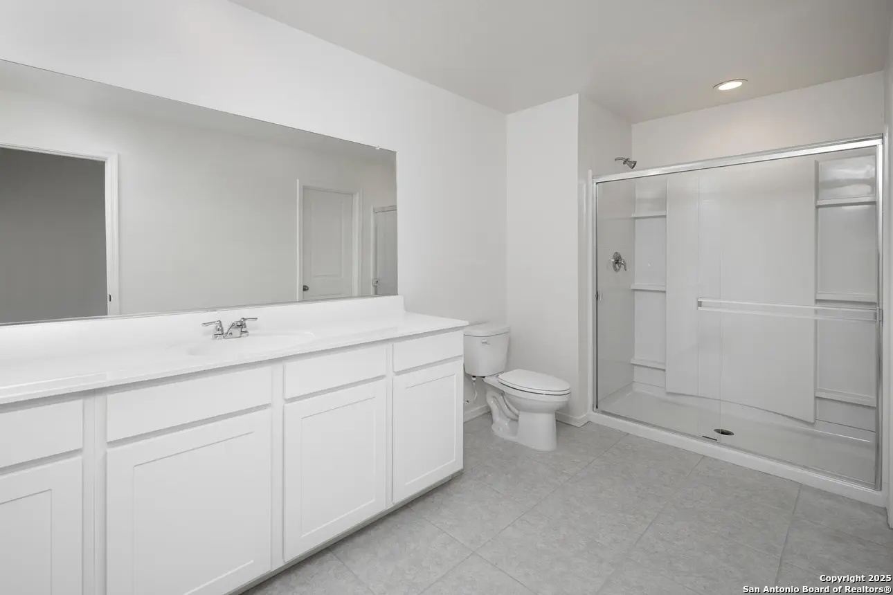 10514 Lesser Snow Adkins, TX 78101 - Photo 11 of 15 a bathroom with a double vanity sink toilet and shower