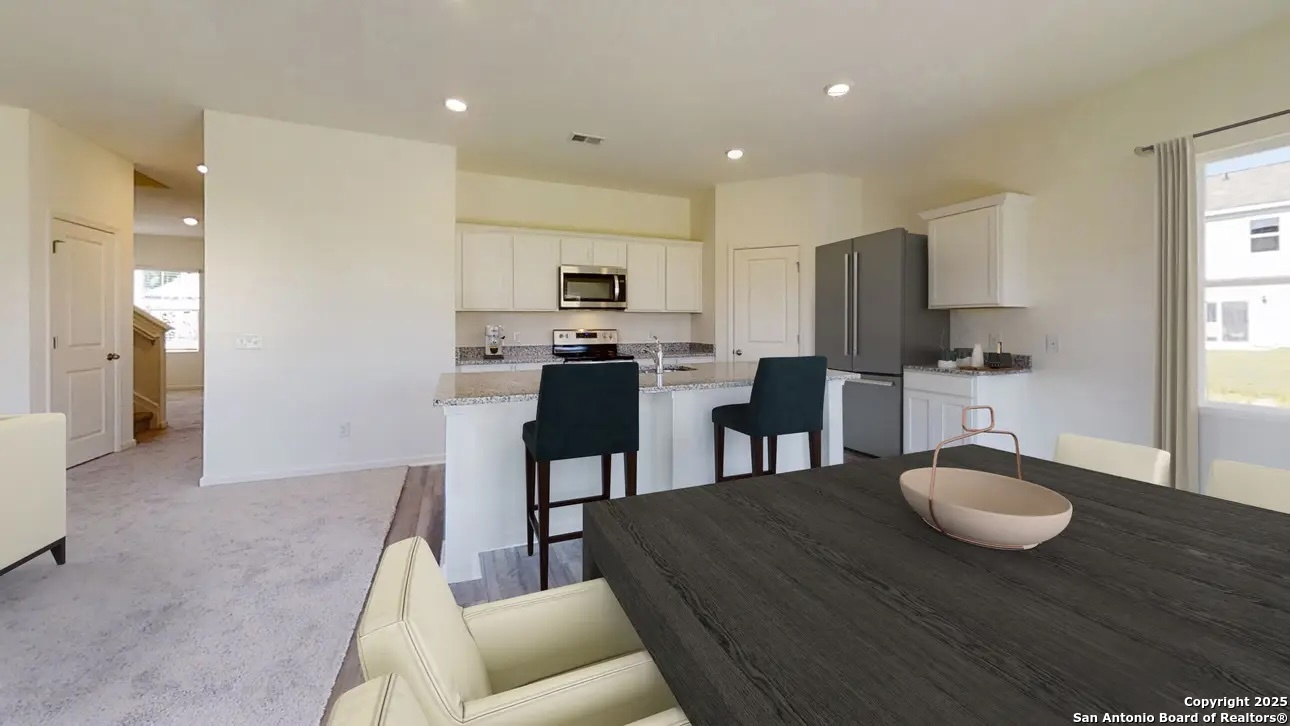 10514 Lesser Snow Adkins, TX 78101 - Photo 3 of 15 a kitchen with kitchen island granite countertop a sink and a refrigerator