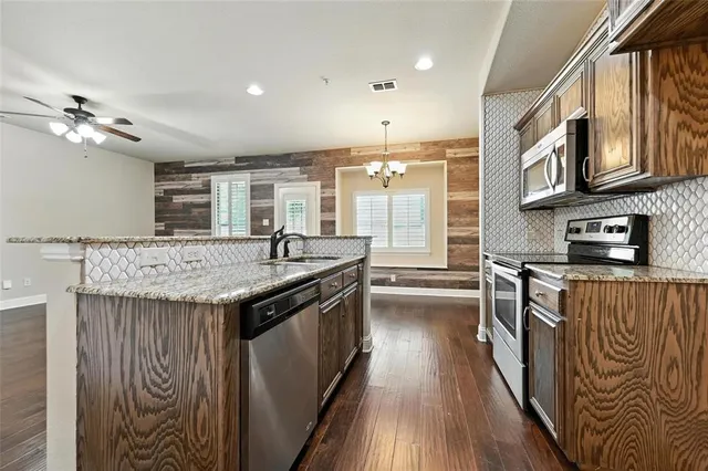 a kitchen with stainless steel appliances granite countertop a stove and a sink