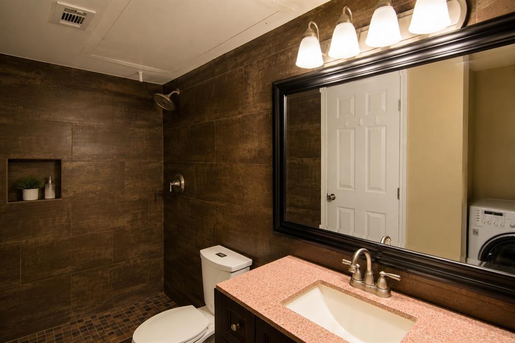18333 Roehampton Drive, Unit 1036 Dallas, TX 75252 - Photo 8 of 12 Bathroom featuring a walk-in shower with large format wall tiles and a built-in niche