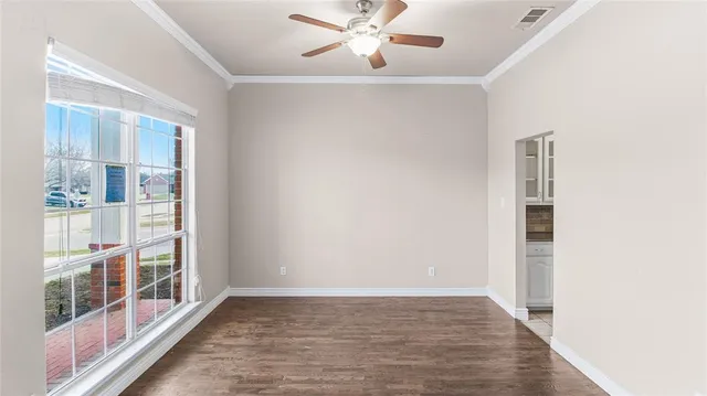 a view of a big room with wooden floor and windows