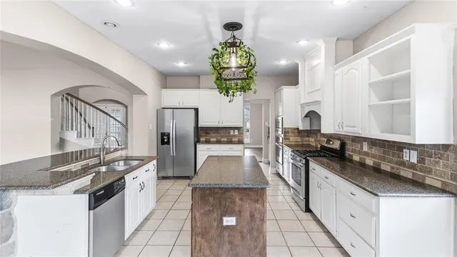 a kitchen with stainless steel appliances granite countertop a sink and stove