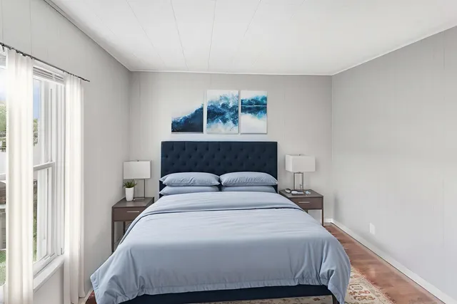 a bedroom with a large bed and a window