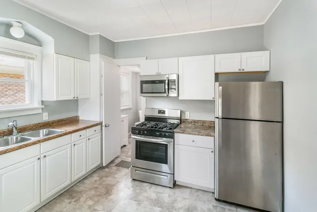a kitchen with white cabinets and white appliances