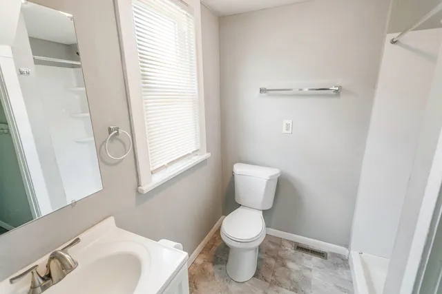 a bathroom with a toilet sink and a mirror