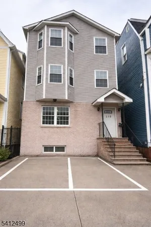 a front view of a house with a yard and seating space