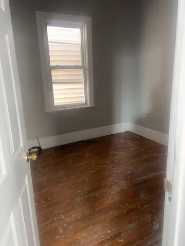 a view of a room with wooden floor and window