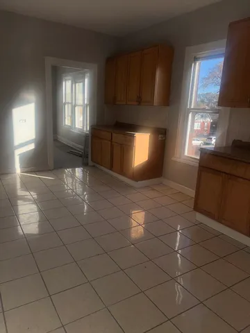 a view of an empty room and window and fire place