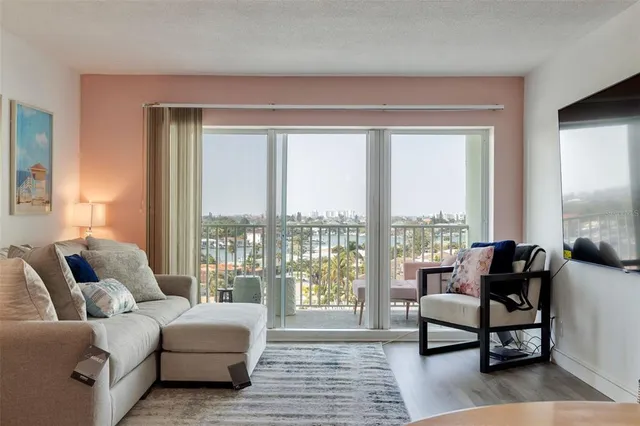 a living room with furniture and view of kitchen